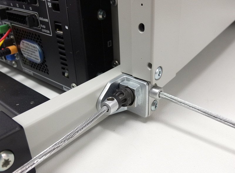Close up of a drag chain mounting bracket and service loop of slack wire at the fixed end near a CNC controller